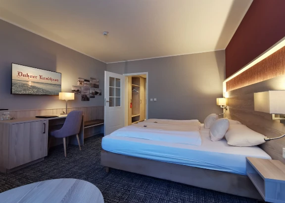 Helles, liebevoll eingerichtetes Hotelzimmer im Duhner Landhaus mit gemütlichem Doppelbett und Sitzgelegenheit