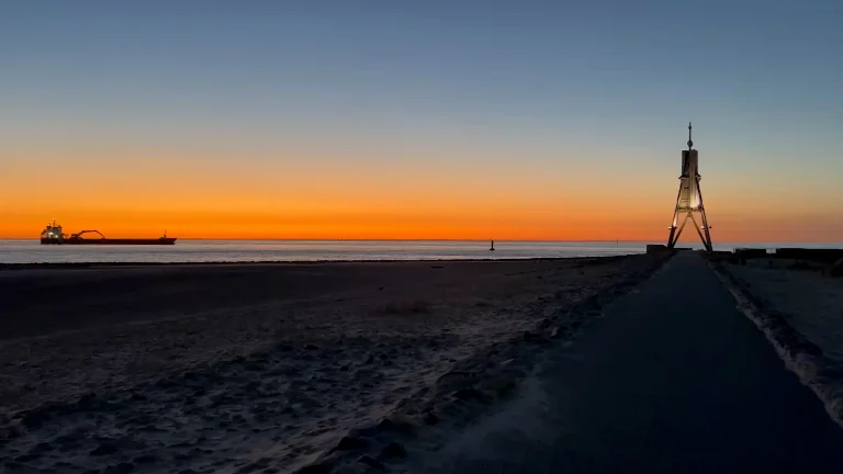 Kugelbake bei Sonnenaufgang mit Schiff in den ersten Lichstrahlen